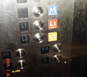 Example of elevator buttons that use colors, large and raised font and braille.